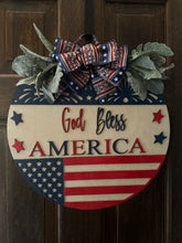Load image into Gallery viewer, God Bless America Door Hanger | 19&quot; Patriotic Round Sign | Hand Painted Birch Wood | 4th of July Front Door Decor
