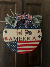 Load image into Gallery viewer, God Bless America Door Hanger | 19&quot; Patriotic Round Sign | Hand Painted Birch Wood | 4th of July Front Door Decor
